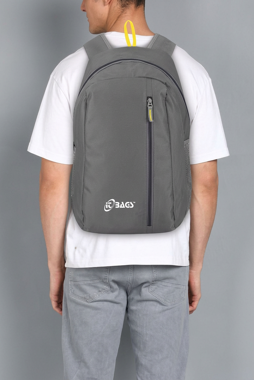 Person wearing a grey backpack with front vertical zip and yellow top loop