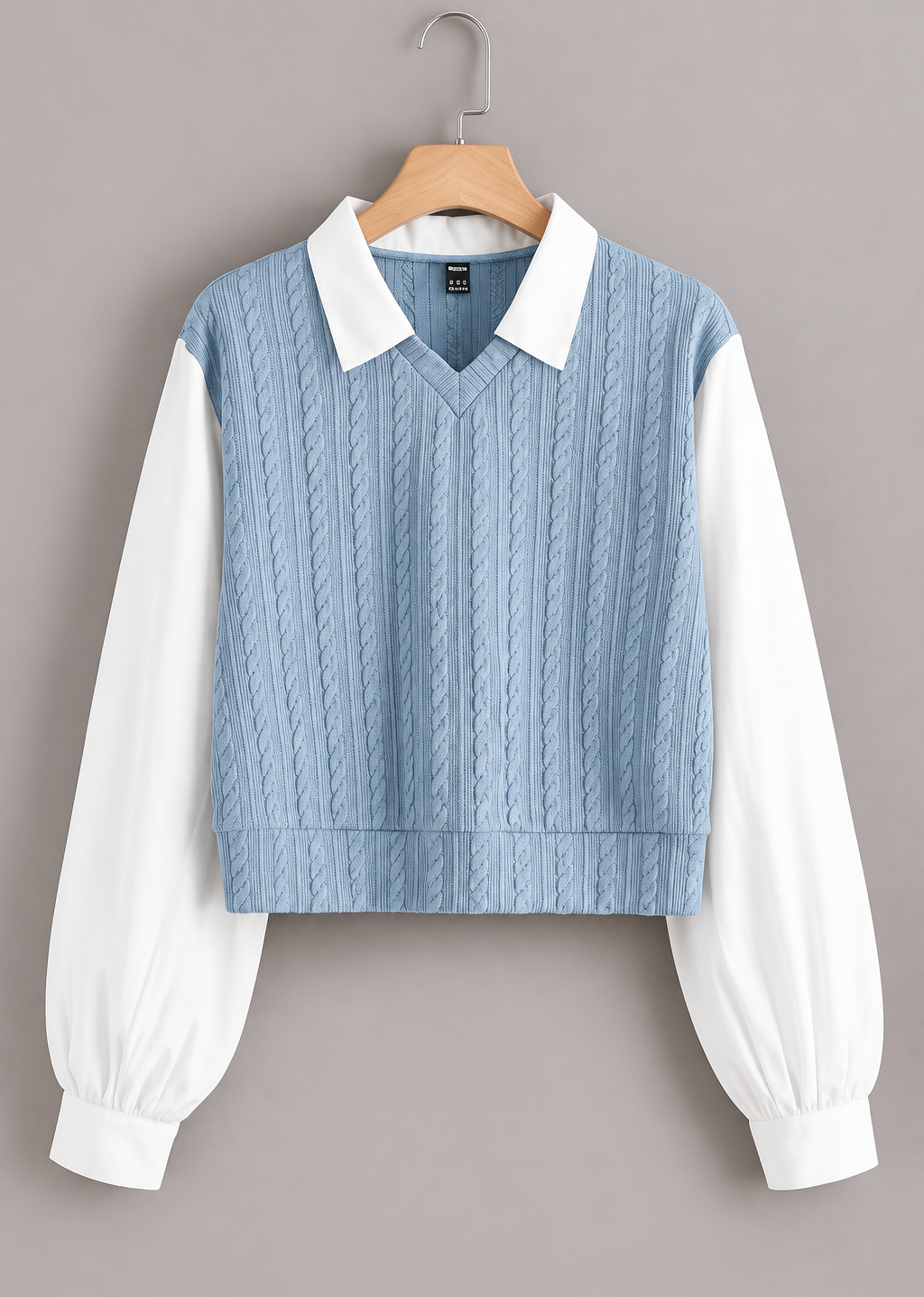 Front view of blue jacquard top with white collar and long white sleeves on a hanger
