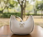 Cream PU half-moon handbag front view with bow accent outdoors