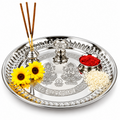 Stainless steel pooja thali with small holders and puja items arranged on the plate